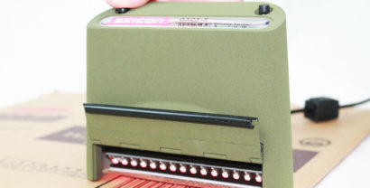 Axicon 6525 barcode verifier forward facing scanning document with red scan light showing