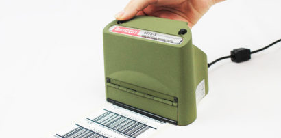 Axicon 6525 barcode scanner hand held facing left scanning a document