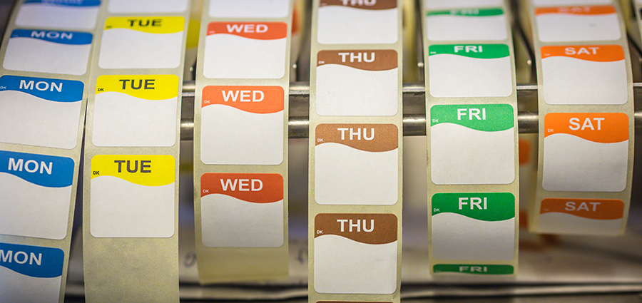 Day dot catering labels / stickers on rolls for food which are pre-printed, colour-coded with days of the week that you can write on or overprint.