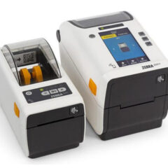 Two Zebra ZD611 Healthcare Printers. On the left is a compact direct thermal model with a transparent cover, and on the right is a larger unit featuring a color touchscreen and advanced navigation controls. Both printers are designed specifically for healthcare environments, offering disinfectant-ready housings and medical-grade power supplies for safe and reliable operation in applications like patient identification, specimen labeling, and medication management.